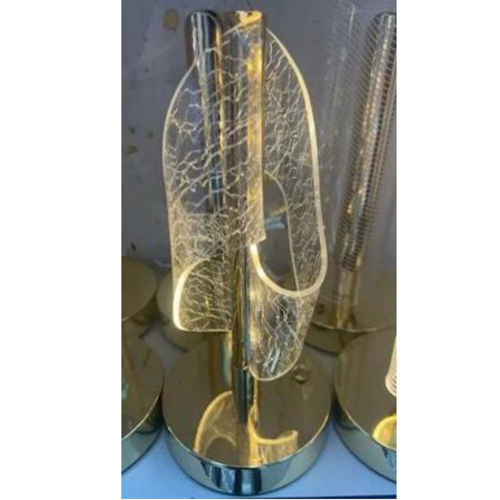 أباجورة مكتب ليد (LED) حديثة، وتشتهر بتصميمها "الترندي" الذي يجمع بين القاعدة الذهبية والغطاء المصنوع من الأكريليك بنقوش تشبه تشققات الكريستال.