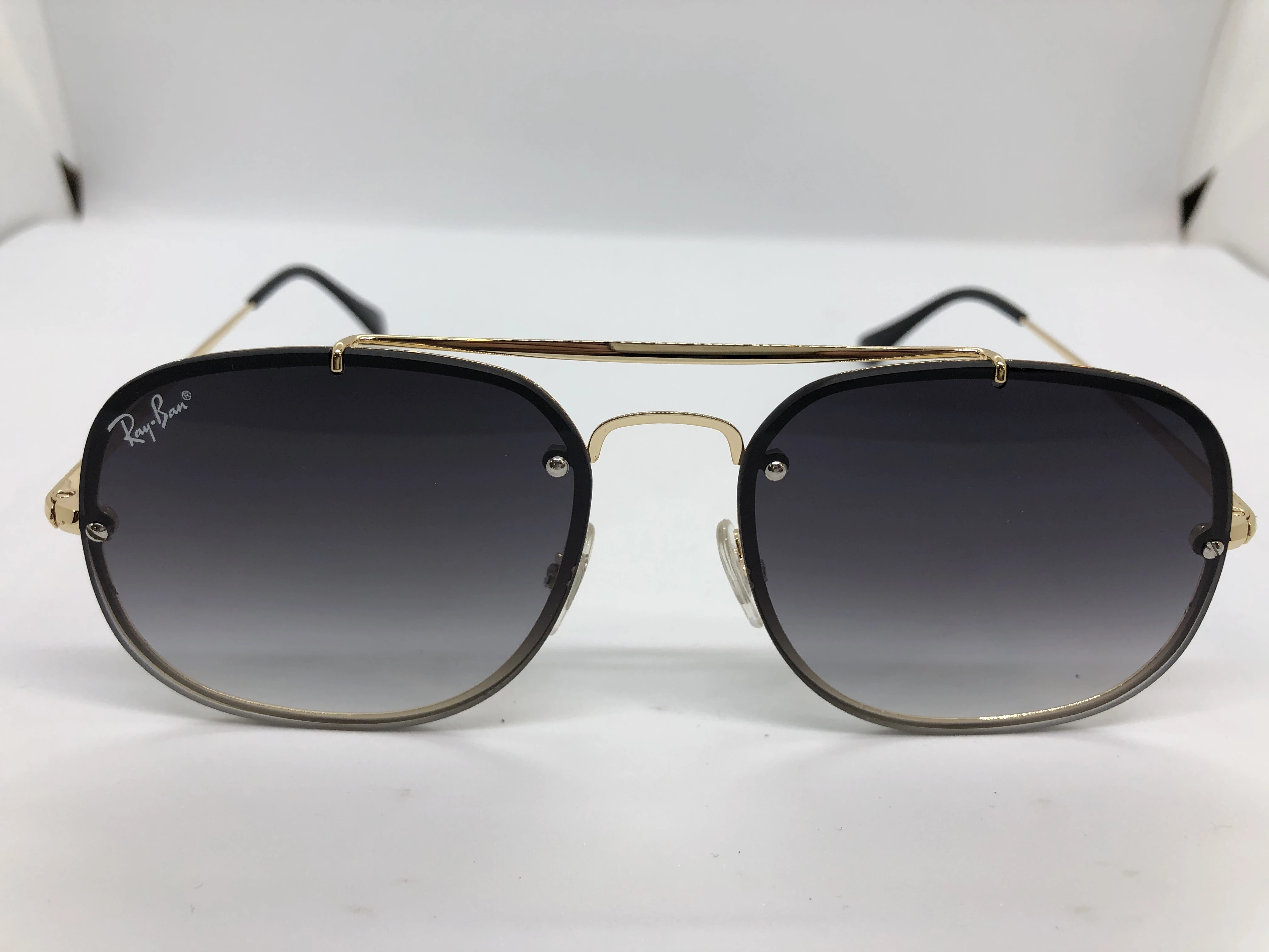 Sunglasses - from Ray Ban - with a golden metal frame - and gradient colored lenses - and a golden metal arm - for men