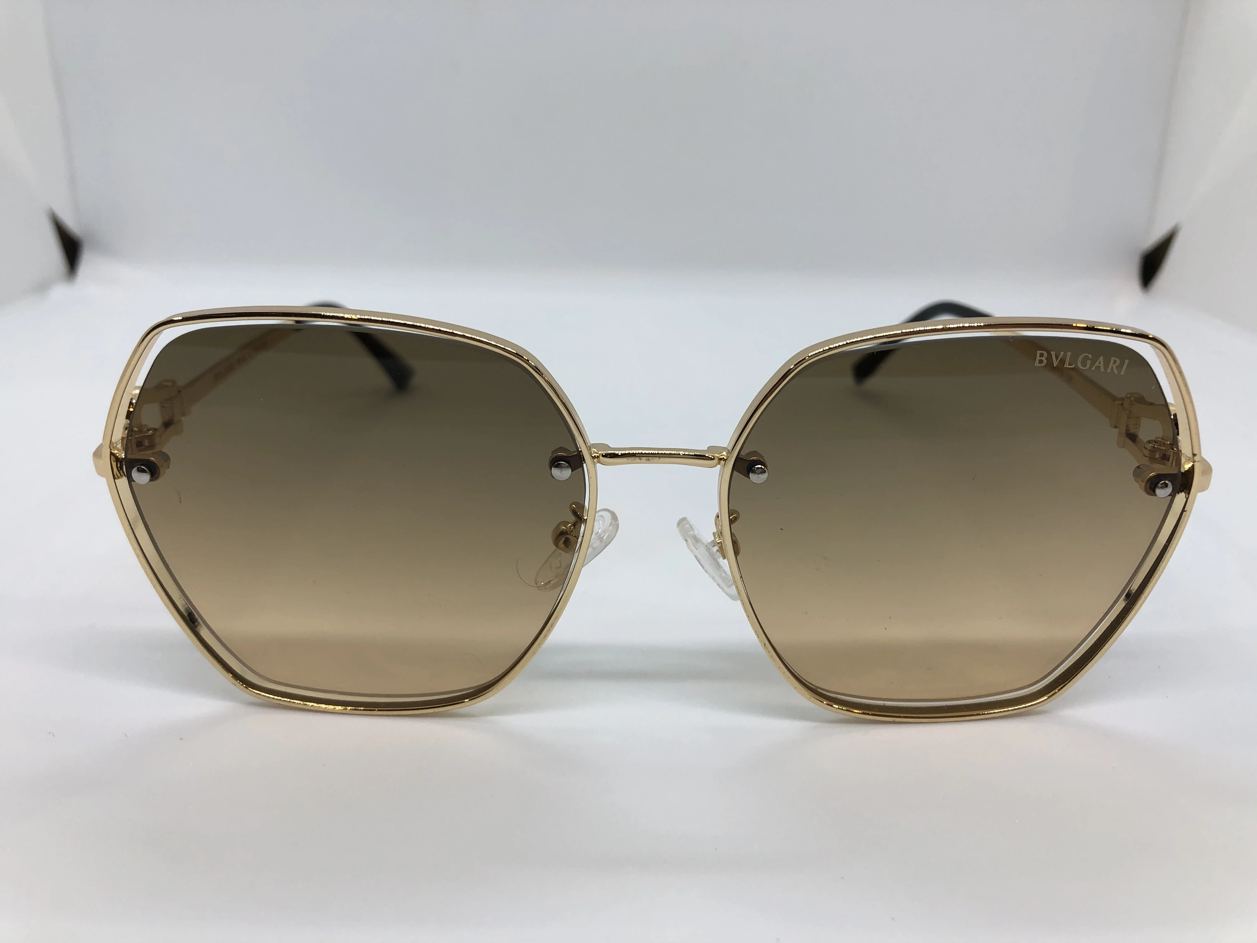 Sunglasses - from Bvlgari - with a golden metal frame - transparent golden lenses - and a golden metal arm - with a golden logo - for women