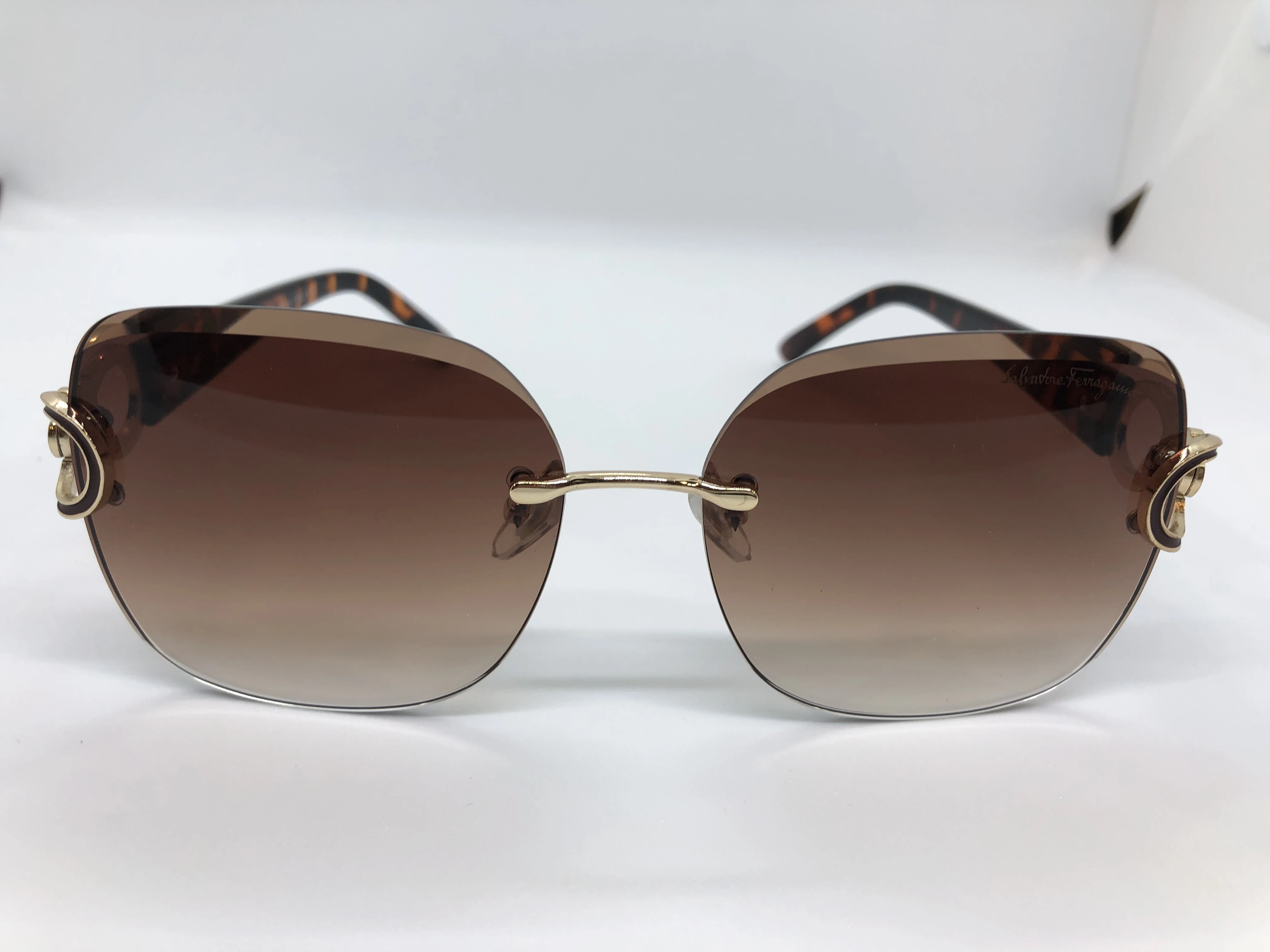 Sunglasses - from Salvatore Ferragamo - without frame - light brown gradient lenses - and dark brown embossed polycarbonate armor - with a golden logo - for women