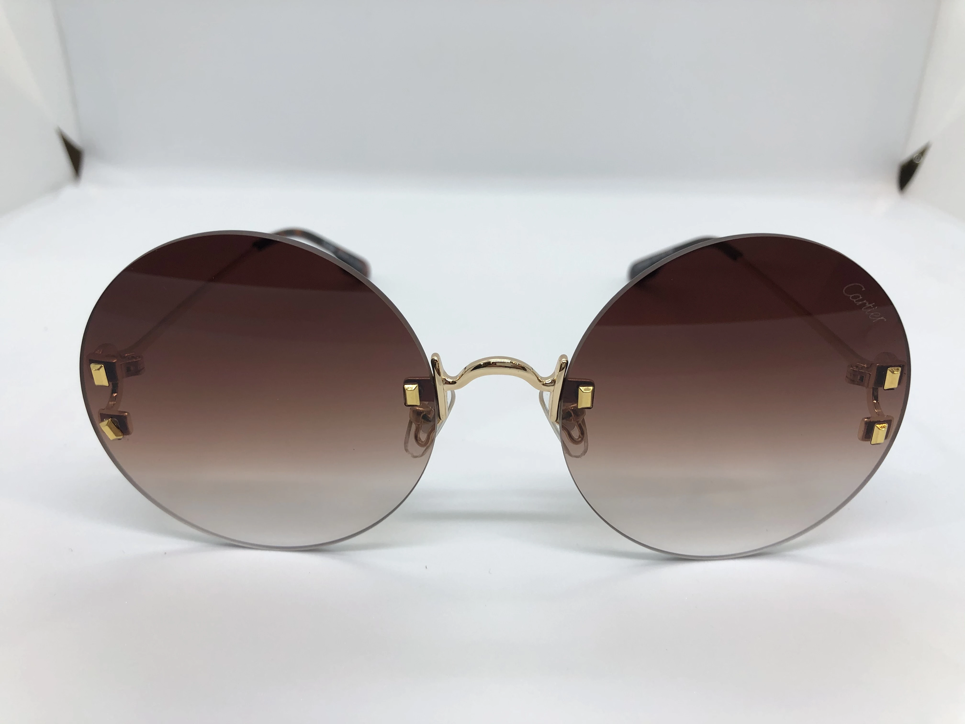 Cartier sunglasses - without frame - with brown gradient lenses - and golden metal arm - for women